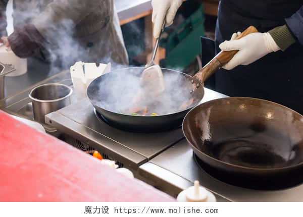 厨师用蒸汽云的商用厨房灶具在煎美食